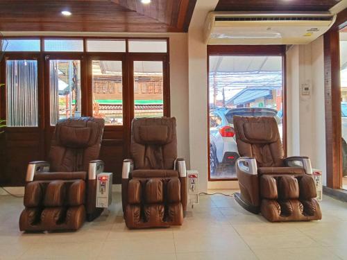 two chairs sitting in front of a building at The Guest Hotel & Hostel in Chiang Mai