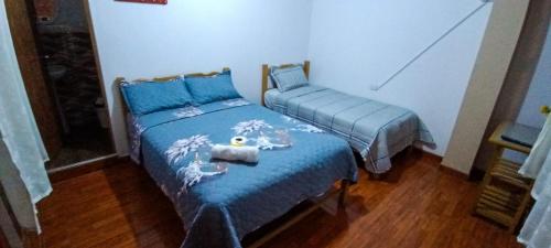 Hospedaje Fortaleza في اوكسابامبا: غرفة نوم بسريرين توأم مع وجود حيوان محشو على السرير