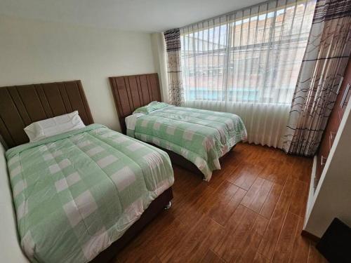 阿雷基帕的住宿－Casa familiar en Arequipa，一间卧室设有两张床和窗户。