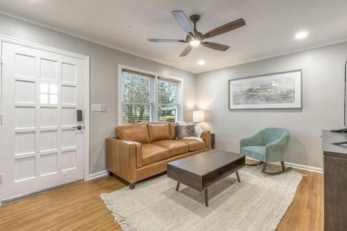 a living room with a couch and a ceiling fan at OneCozyPlace Tulsa - King Bed Expo, TU, Downtown in Tulsa