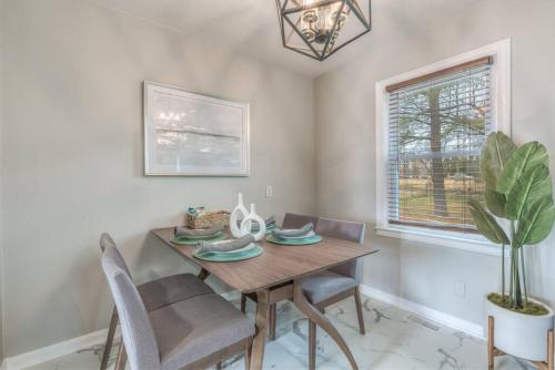 a dining room with a table and chairs and a plant at OneCozyPlace Tulsa - King Bed Expo, TU, Downtown in Tulsa