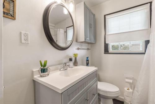 a white bathroom with a sink and a mirror at Tulsa Home Sweet Home - King Bed Near Expo, TU, Dtwn in Tulsa