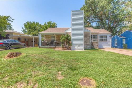 a house with a car parked in a yard at Tulsa Home Sweet Home - King Bed Near Expo, TU, Dtwn in Tulsa