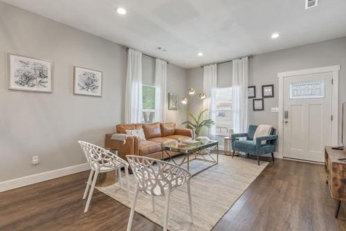 a living room with a couch and a table at Tulsa Boho Bungalow | King Bed• Near Dtwn•EXPO•TU in Tulsa