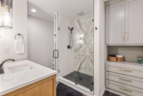 a white bathroom with a shower and a sink at Trendy in Tulsa - King Bed Expo, TU, Downtown in Tulsa