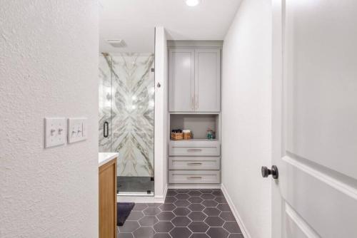 a bathroom with a hallway with a sink and a door at Trendy in Tulsa - King Bed Expo, TU, Downtown in Tulsa