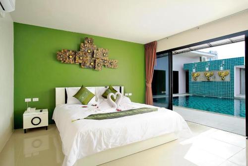 1 dormitorio con cama y piscina en Gu Hotel Patong, en Patong Beach