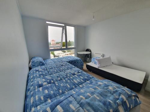 バルディビアにあるDepartamento estudio isla Teja equipadoのベッド2台と窓のある寝室