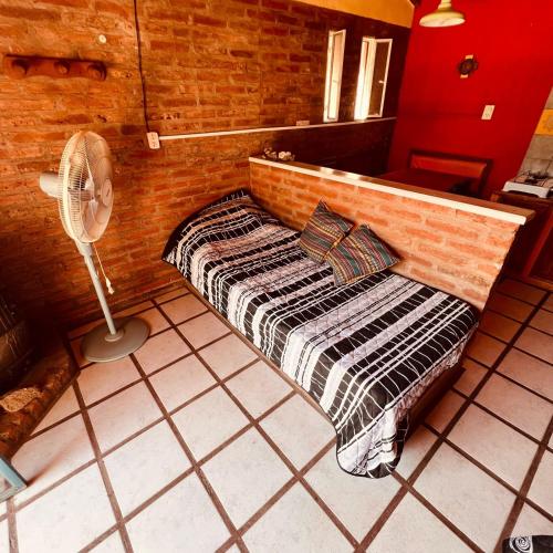 a small bed in a room with a fan at June en el Uritorco in Capilla del Monte