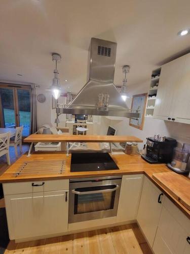 une cuisine avec des armoires blanches et un four à plaques de cuisson dans l'établissement Chamonix Garden Flat with a View of Mont-Blanc - Référence XEPKMM, à Chamonix-Mont-Blanc