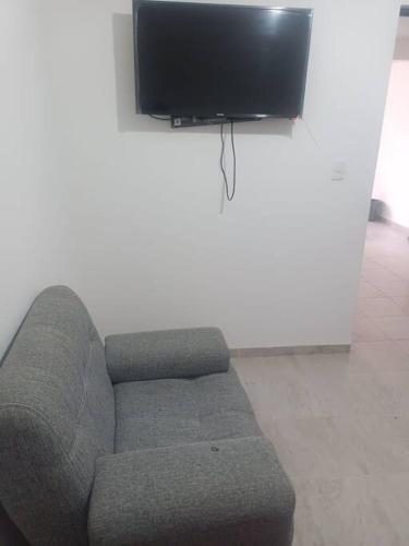 a living room with a couch and a flat screen tv at Excelente hogar para descansar in Gómez