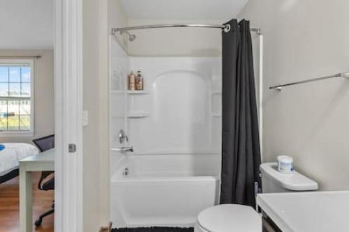 a bathroom with a tub and a toilet and a shower at Corporate Housing MGM in Detroit