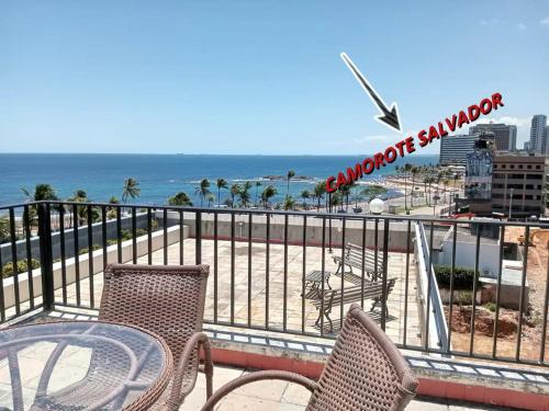 a balcony with a table and chairs and the ocean at Studio charmoso na praia de Ondina perto de tudo in Salvador
