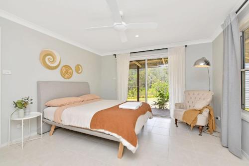 1 dormitorio con 1 cama, 1 silla y 1 ventana en Off the grid in Laguna Haven A 100-Acre Oasis of Sustainable Serenity en Laguna