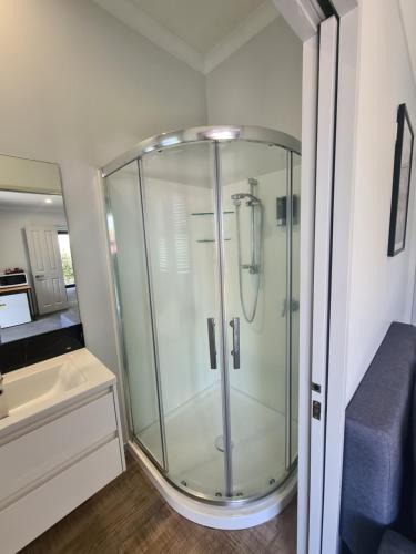 a glass shower in a small bathroom with a sink at Bonnie Doone in Te Awamutu