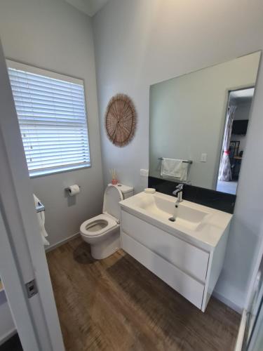 a bathroom with a white sink and a toilet at Bonnie Doone in Te Awamutu