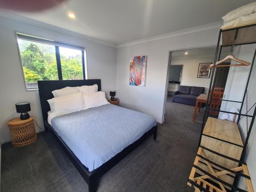 a bedroom with a bed and a ladder and a living room at Bonnie Doone in Te Awamutu