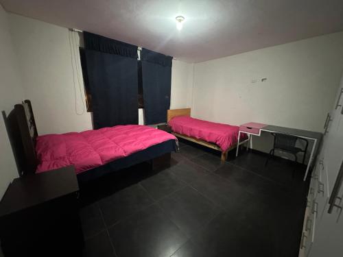 een kamer met 2 bedden, een bureau en een raam bij Departamento en playa San Bartolo - cuarto piso in San Bartolo