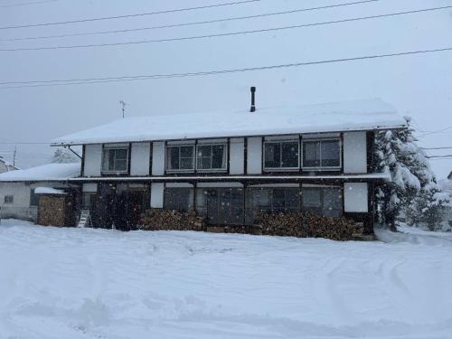 a house with snow on the roof of it at 白馬の黒馬　DarkHorse @Hakuba in Hakuba