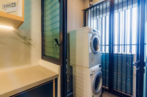 a washer and dryer in a room with a window at Son&Henry Zenity District 1 in Ho Chi Minh City