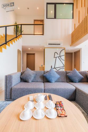 a living room with a couch and a table at Son&Henry Zenity District 1 in Ho Chi Minh City