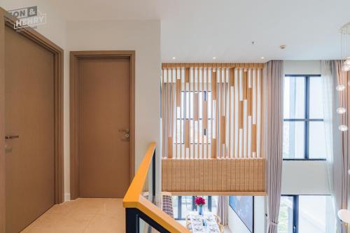 a room with a staircase with a chair and a window at Son&Henry Zenity District 1 in Ho Chi Minh City