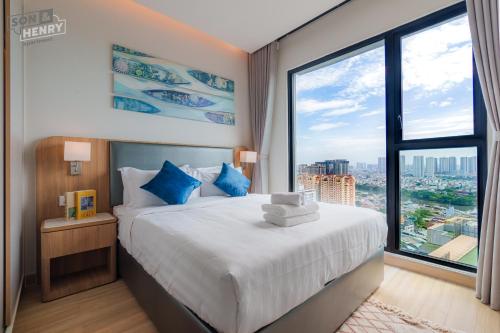 a bedroom with a bed and a large window at Son&Henry Zenity District 1 in Ho Chi Minh City
