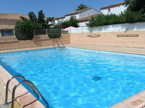 - une grande piscine bleue avec des chaises dans l'établissement Villa de Charme avec Piscine, Terrasse et VTT, Proche Plage et Commerces - 6 Pers. - FR-1-749-29, au Cap d'Agde