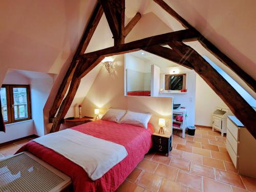 una camera da letto con un grande letto in mansarda di Séjour paisible au cœur du Berry : maison familiale moderne, cheminée, jardin, et SPA à Cléré-du-Bois. - FR-1-591-563 a Cléré-du-Bois