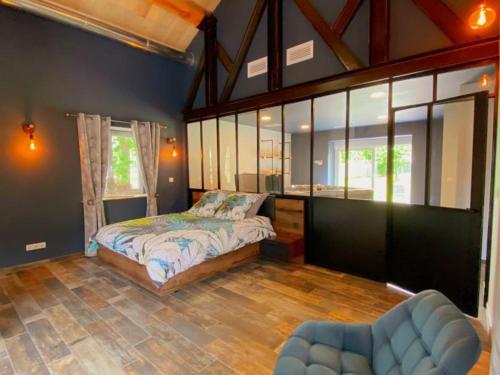 a bedroom with a bed and a large window at Loft industriel avec Spa, Sauna et Hammam en Touraine – Jardin clos et équipements haut de gamme - FR-1-381-559 in Marigny-Marmande