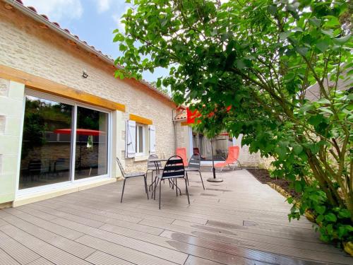 a wooden deck with chairs and a table on it at Loft industriel avec Spa, Sauna et Hammam en Touraine – Jardin clos et équipements haut de gamme - FR-1-381-559 in Marigny-Marmande