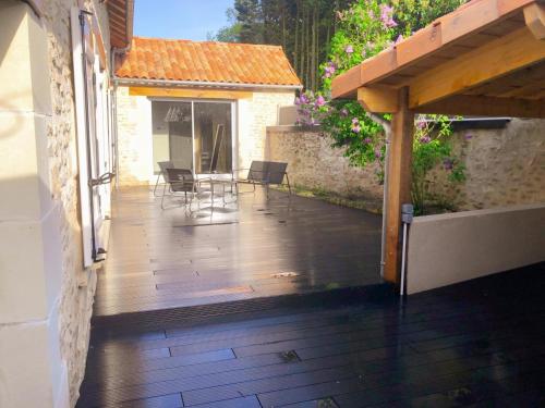 an open patio with chairs and a wooden deck at Loft industriel avec Spa, Sauna et Hammam en Touraine – Jardin clos et équipements haut de gamme - FR-1-381-559 in Marigny-Marmande