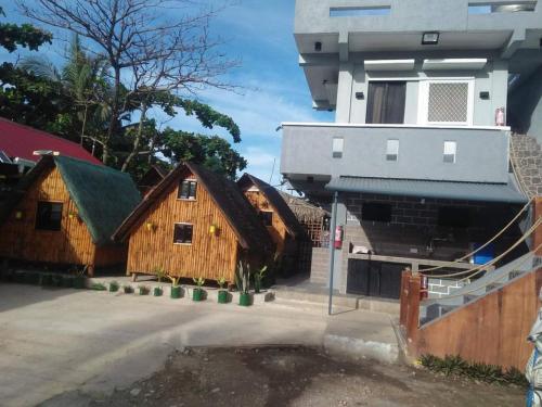 Kua's Pad Batangas Room في ليان: مجموعة مباني خشبية امام مبنى
