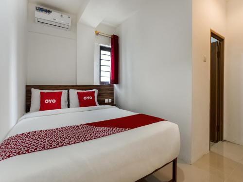 a bedroom with a large bed with red pillows at Super OYO Capital O 3463 Cimahi Guest House in Bandung