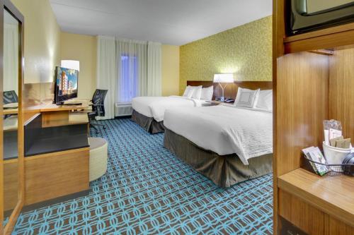 a hotel room with two beds and a flat screen tv at Fairfield Inn & Suites by Marriott Asheville Tunnel Road in Asheville