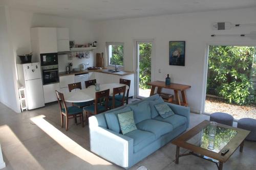 a living room with a blue couch and a kitchen at Casa Playera in Puchuncaví