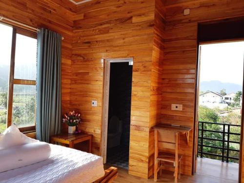 Diep Le Homestay في فونغ نها: غرفة نوم بجدران خشبية وسرير ومكتب