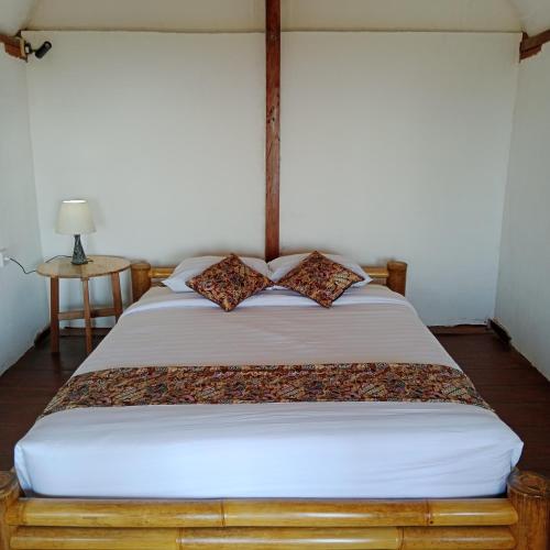 1 dormitorio con 1 cama con marco de madera en Bali jungle cabin, en Jatiluwih