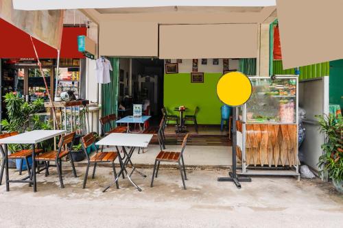 a restaurant with tables and chairs and a green wall at Hotel O Wr House Syariah BatamNearEast Coast Park in Jodoh