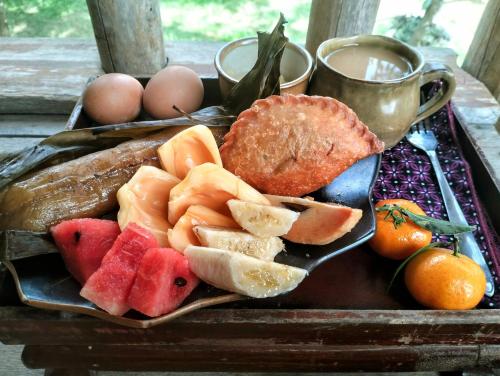 a tray of food with fruit and bread and eggs at Banteay Srey Women's Only Traditional Spa and Homestay in Kampot