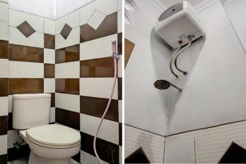 a bathroom with a toilet and a soap dispenser at OYO 92065 Kos Flobamor in Kupang