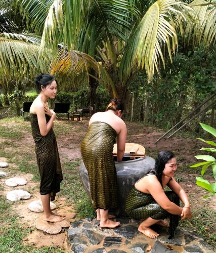 a group of three women standing around a bath tub at Banteay Srey Women's Only Traditional Spa and Homestay in Kampot