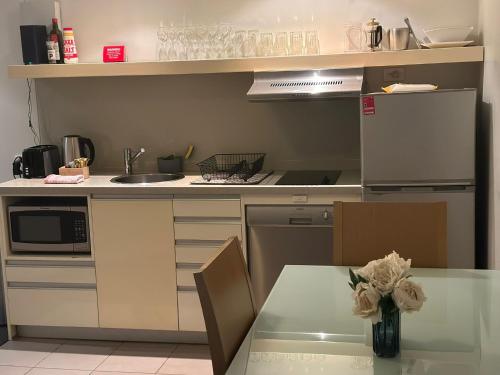 a kitchen with a table and a counter top at Pandanas Apt 5 15th fl Darwin CBD Harbor views in Darwin