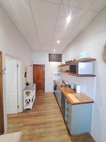 cocina con paredes blancas y suelo de madera en The Stetson, en Paarl