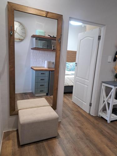 a mirror and a stool in a room with a bedroom at The Stetson in Paarl
