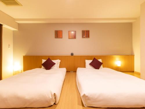 two beds in a room with white sheets at Tokyu Stay Monzen-Nakacho in Tokyo