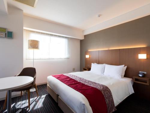 a hotel room with a large bed and a table at Tokyu Stay Monzen-Nakacho Tokyo in Tokyo