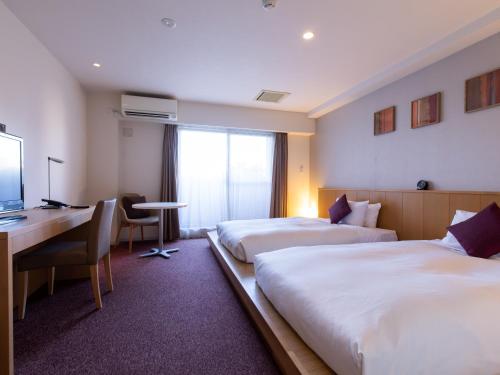 a hotel room with two beds and a desk at Tokyu Stay Monzen-Nakacho Tokyo in Tokyo