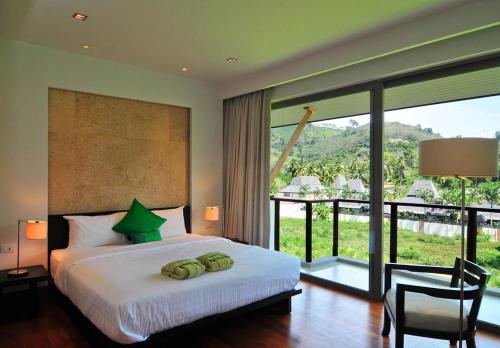 een slaapkamer met een bed en een groot raam bij Pearl of Naithon in Nai Thon Beach