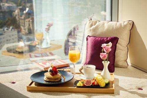 a table with pancakes and juice and a tray of food at Sheraton Bucharest Hotel in Bucharest